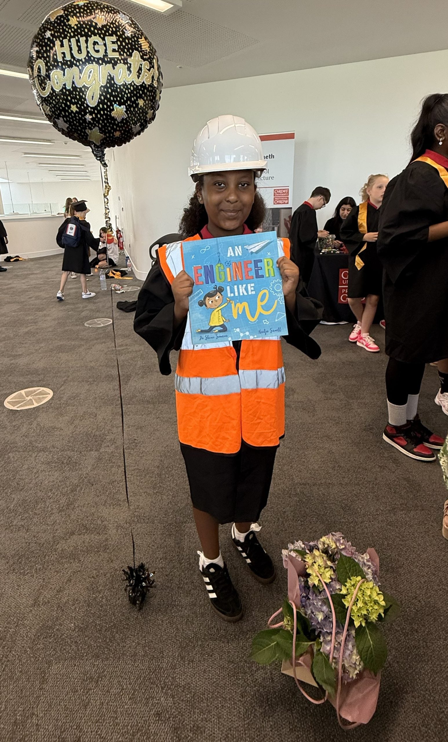 Figure 3. Girl interested in becoming a Civil Engineer, wearing personal protective equipment, posing with the book 
